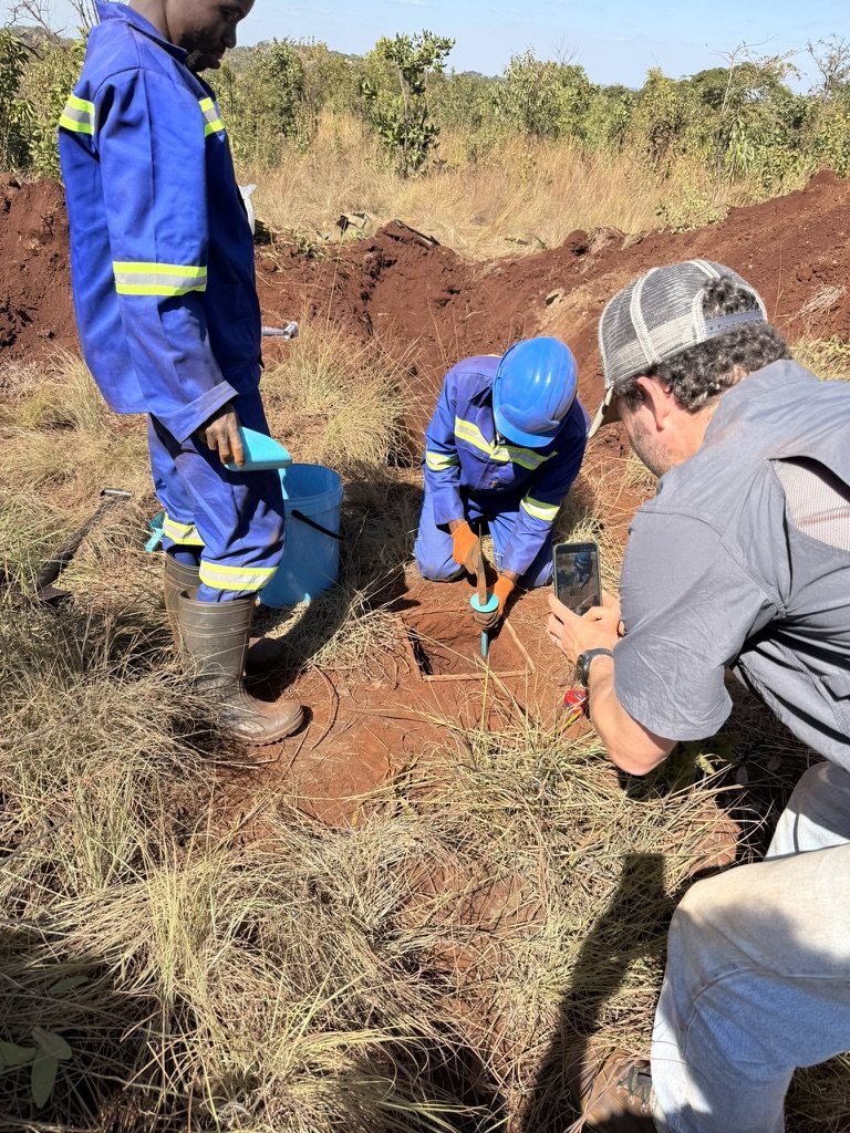 Taking a sample at the bottom of a pit, with a bucket and sampling tool
