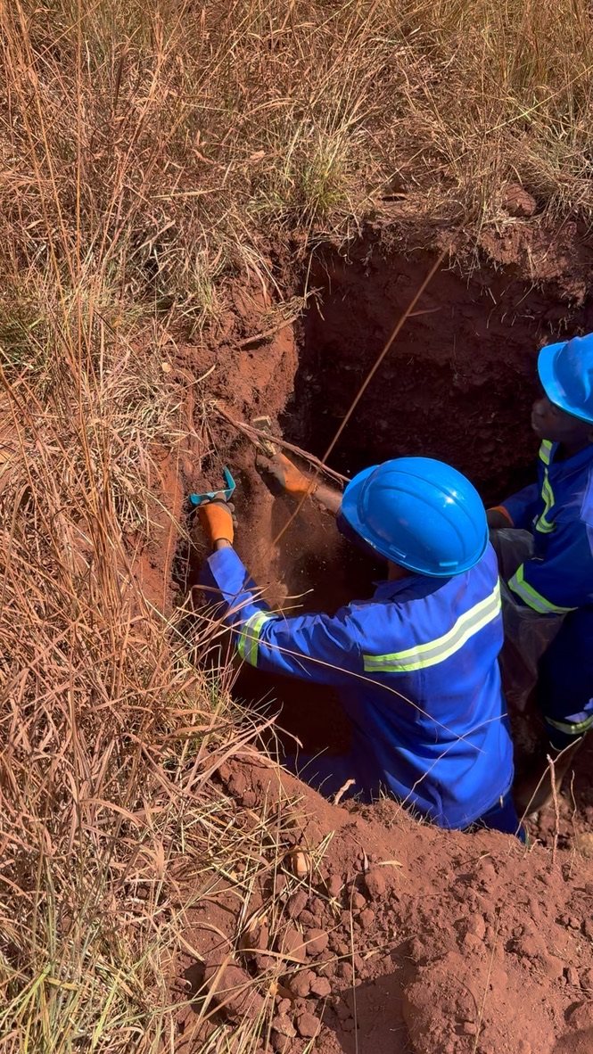 A worker taking a sample from the wall of a pit