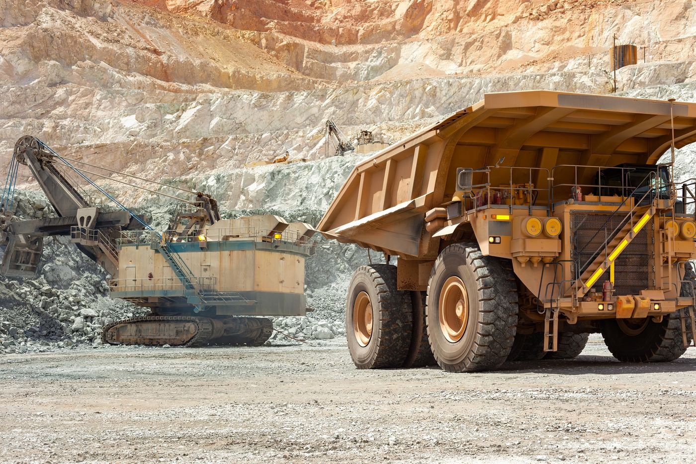 An electric shovel loading a large haul truck in a quarried pit