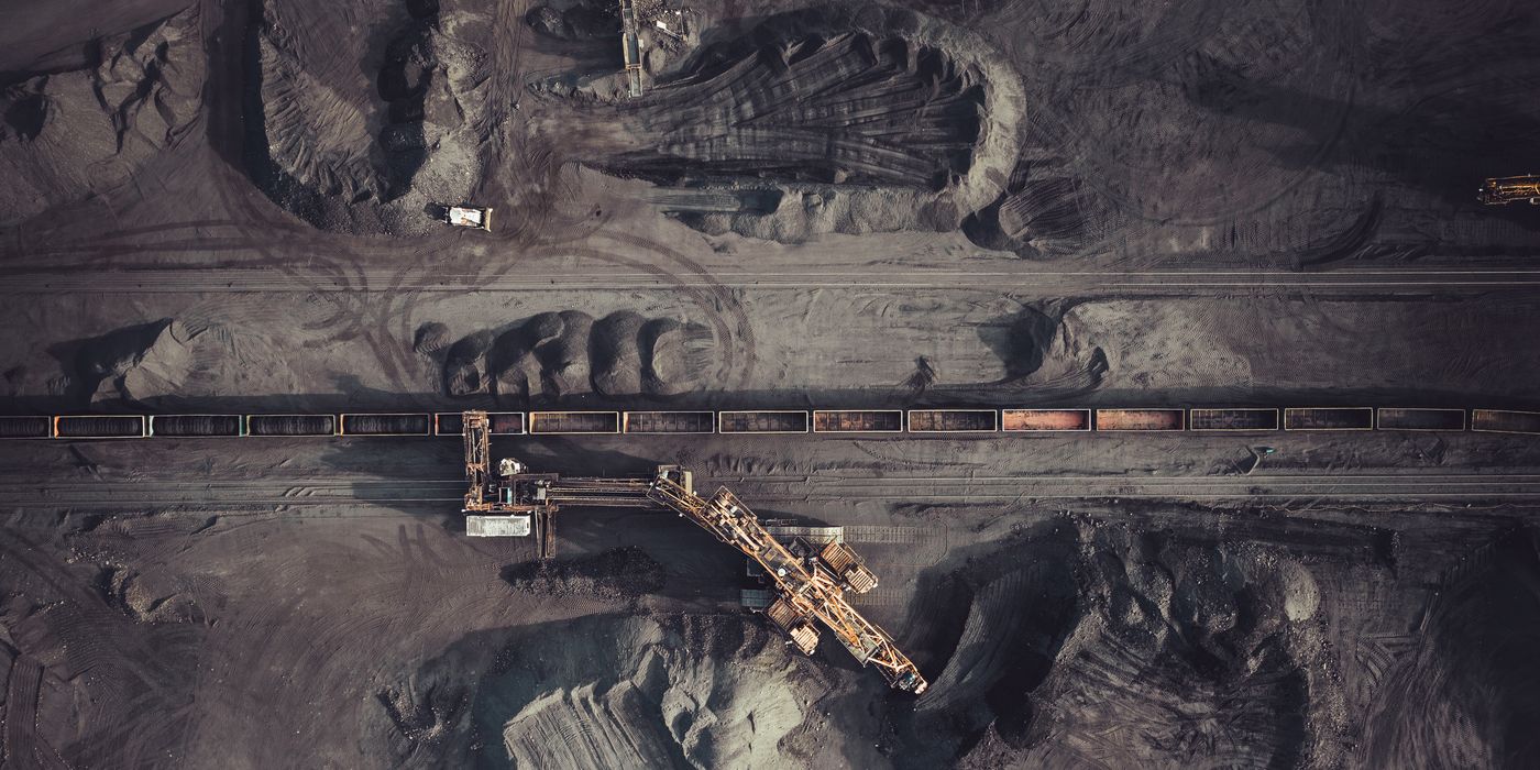 Aerial view of a mine stockyard, with a loading conveyor beside a train of ore wagons